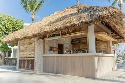 a restaurant with a thatched roof at Bahia Principe Grand Punta Cana - All Inclusive in Punta Cana