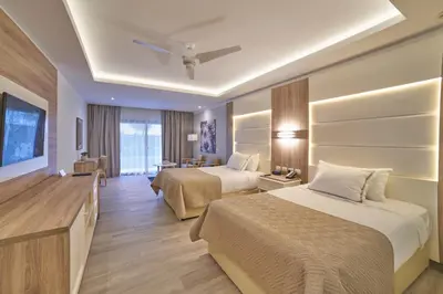 a hotel room with two beds and a television at Bahia Principe Luxury Ambar - Adults Only All Inclusive in Punta Cana
