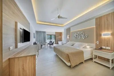 a bedroom with a bed and a living room at Bahia Principe Luxury Ambar - Adults Only All Inclusive in Punta Cana