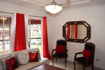 a living room with a couch and two chairs and a mirror at Three-Bedroom Apartment 3 in Santo Domingo