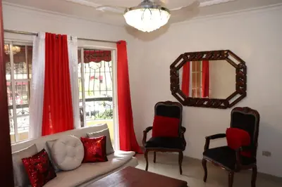 a living room with a couch and chairs and a mirror at Three-Bedroom Apartment 3 in Santo Domingo