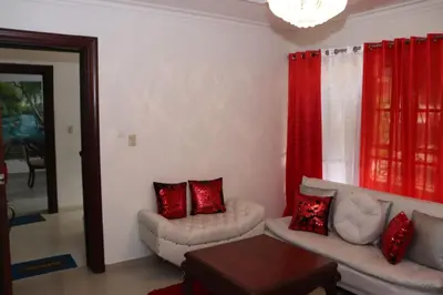 a living room with two couches and a red curtain at Three-Bedroom Apartment 3 in Santo Domingo