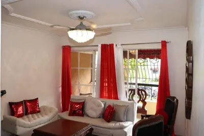 a living room with red curtains and a table and chairs at Three-Bedroom Apartment 3 in Santo Domingo