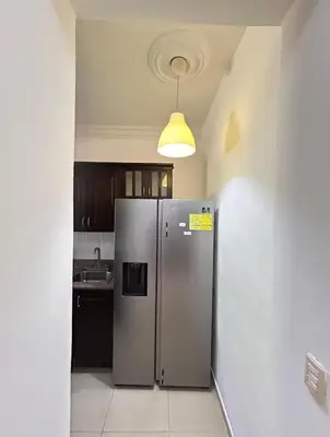 a stainless steel refrigerator in a kitchen with a light at Disfruta momentos inolvidables in Santo Domingo