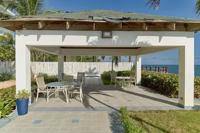 a patio with a table and chairs and the ocean at El Retiro Juan Dolio Beach by Elital Luxury in Villas del Mar