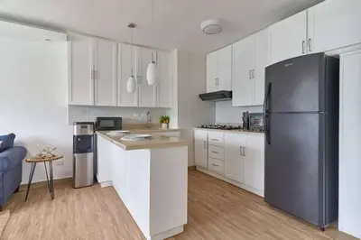 a kitchen with white cabinets and a stainless steel refrigerator at El Retiro Juan Dolio Beach by Elital Luxury in Villas del Mar