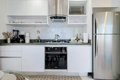 a kitchen with white cabinets and a stainless steel refrigerator at Chic Centric 1BR Apt, King Bed in Los Prados