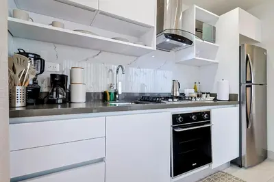 a kitchen with white cabinets and a stainless steel refrigerator at Chic Centric 1BR Apt, King Bed in Los Prados