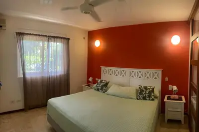 a bedroom with a bed and a red wall at Apartamento centro y playa in Las Terrenas
