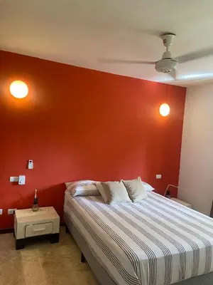 a bedroom with a red wall with a bed at Apartamento centro y playa in Las Terrenas