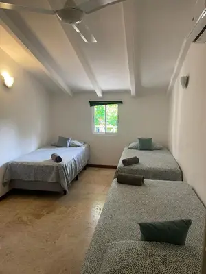a room with two beds and a window at Apartamento centro y playa in Las Terrenas