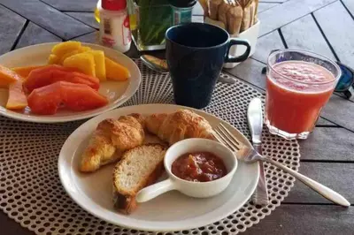 a table with two plates of breakfast food and a drink at Beach, nature and relaxation in Las Terrenas