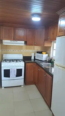 a kitchen with a white stove and a white refrigerator at guababerry Juan dolio in Los Conucos