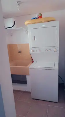 a small kitchen with a white refrigerator and a sink at guababerry Juan dolio in Los Conucos