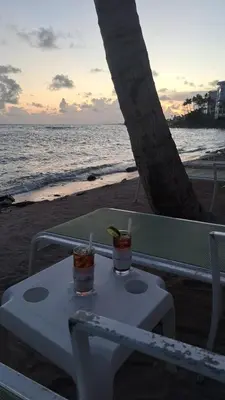 two drinks sitting on a table on the beach at guababerry Juan dolio in Los Conucos