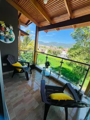 a room with two chairs and a large window at Apartamento Brisas de la Montaña in Jarabacoa