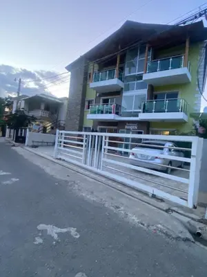 a white fence in front of a building at Apartamento Brisas de la Montaña in Jarabacoa