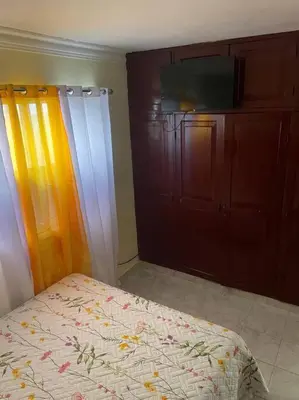 a bedroom with a bed and a dresser and a television at cabrera villa con vista al mar in Cabrera