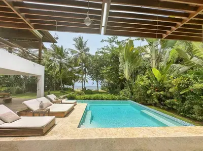 a swimming pool in a yard with two couches at Oceanfront Villa with Staff, Private Pool, BBQ in Las Terrenas