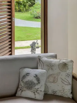 a couch with two pillows in front of a window at Oceanfront Villa with Staff, Private Pool, BBQ in Las Terrenas