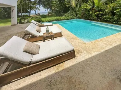 a swimming pool with chaise lounge chairs and a swimming pool at Oceanfront Villa with Staff, Private Pool, BBQ in Las Terrenas
