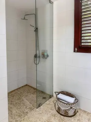 a bathroom with a glass shower with a basket at Oceanfront Villa with Staff, Private Pool, BBQ in Las Terrenas