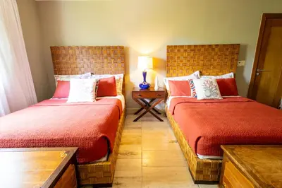 a bedroom with two beds and a table with a lamp at Sunset Cove at Balcones in Las Terrenas
