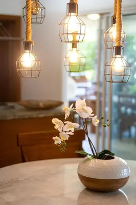 a vase with flowers sitting on a table with lights at Sunset Cove at Balcones in Las Terrenas