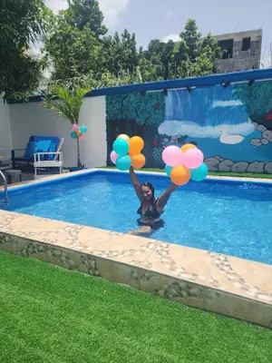a woman holding balloons in a swimming pool at Villa Luz in Andrés