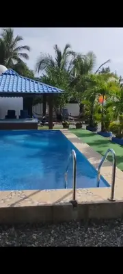 a large blue swimming pool with a gazebo at Villa Luz in Andrés