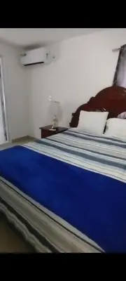 a bedroom with a bed with blue sheets and pillows at Villa Luz in Andrés