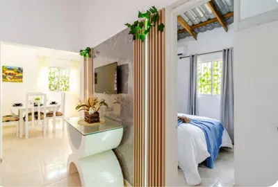 a bedroom with a bed and a dining room at Escape to Puerto Plata, Cozy 2BR Loft in Las Mercedes, 5 Min from Beaches in Isabel de Torres