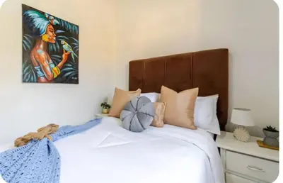 a bedroom with a white bed with a wooden headboard at Escape to Puerto Plata, Cozy 2BR Loft in Las Mercedes, 5 Min from Beaches in Isabel de Torres