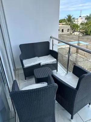 a balcony with two chairs and a table and a couch at Apartamentos victoria in Las Terrenas