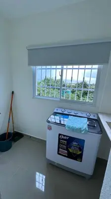 a small stove in a room with a window at Hospedaje Lujoso en Boca Chica in Santo Domingo
