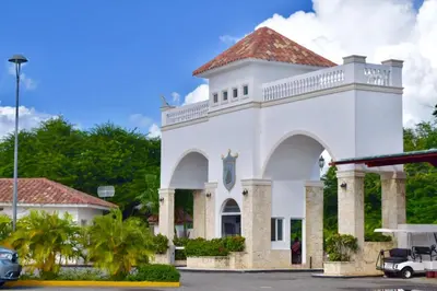 a white building with a clock on it at Beach Day at CadaquesCaribe Bayahibe in Bayahibe