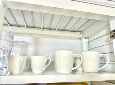 a row of white cups sitting on a shelf at Villa Olímpica Doble Vía in Marilópez