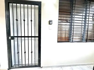 a door with a black gate and a window at Villa Olímpica Doble Vía in Marilópez