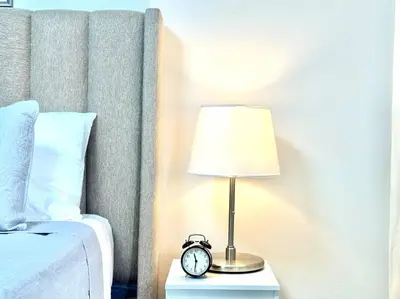 a bed with a lamp and a clock on a night stand at Villa Olímpica Doble Vía in Marilópez