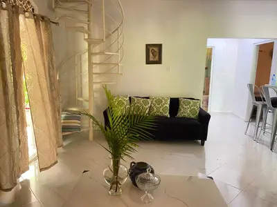 a living room with a black couch and a table at Casa de adela in Cruce de Veragua