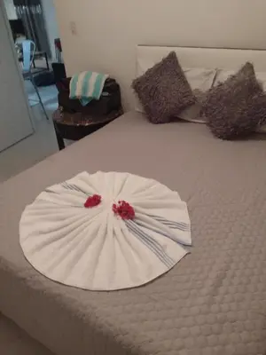 a white dress on a bed with red flowers on it at Casa de adela in Cruce de Veragua