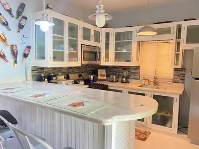 a kitchen with white cabinets and a white counter top at Casa de adela in Cruce de Veragua