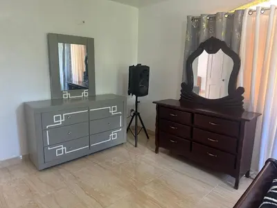 a bedroom with a dresser and a mirror and a dresser at Casa las Américas in La Alianza
