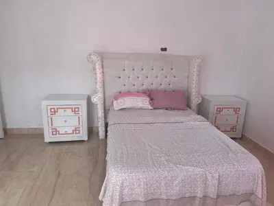 a bedroom with a white bed and two night stands at Casa las Américas in La Alianza