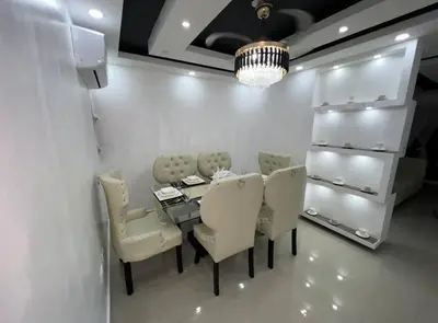 a dining room with a table and chairs and a chandelier at Apartamento lujoso y cómodo in Santo Domingo