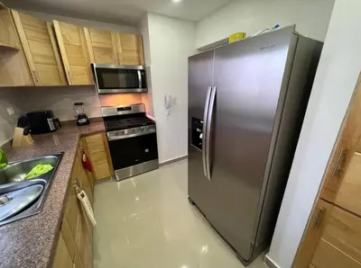 a kitchen with a stainless steel refrigerator and a stove at Apartamento lujoso y cómodo in Santo Domingo