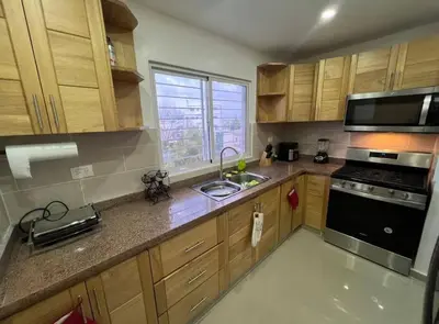 a kitchen with a sink and a stove top oven at Apartamento lujoso y cómodo in Santo Domingo