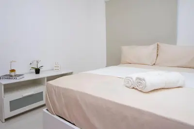 a white bedroom with a bed with towels on it at APT 3 HAB Avenida España Piso 1 in La Viva