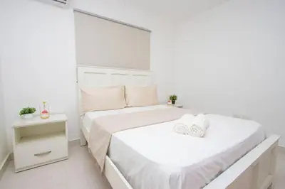 a white bedroom with two beds and a mirror at APT 3 HAB Avenida España Piso 1 in La Viva