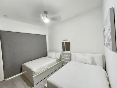 a small room with two beds and a window at Melody 2BDR Condo with Pool View in Coral Bay #2 in Punta Cana
